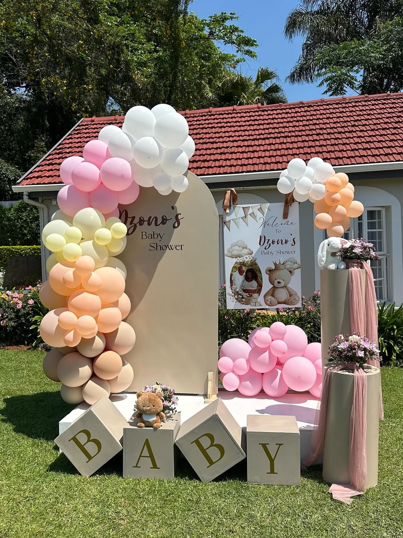 Dzono's baby shower balloon arch in peach and cream tones