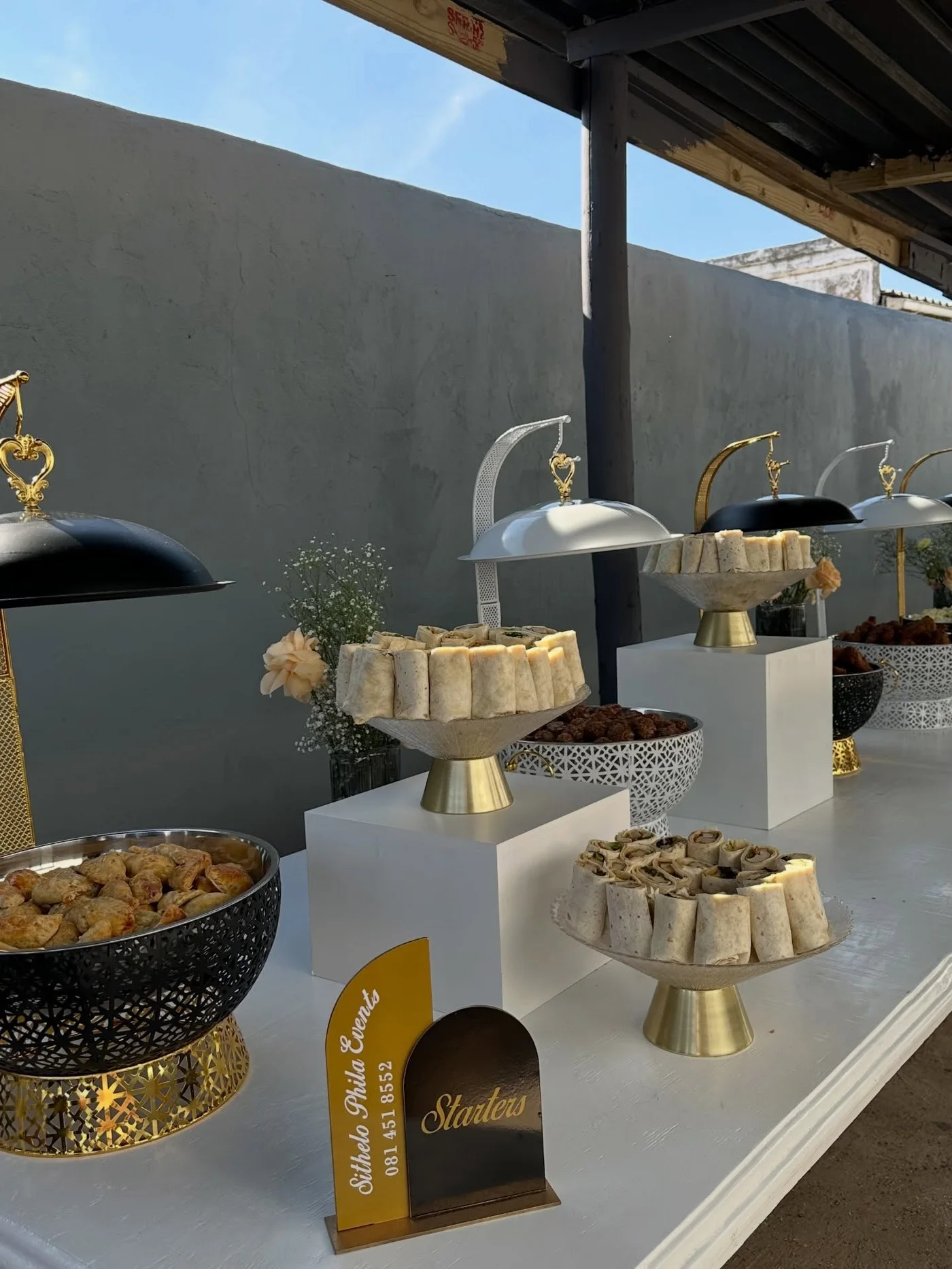 Catering starters served under gold cloche domes by Sithelo Phila Events
